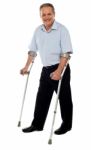 Senior Man Standing With Crutches Stock Photo