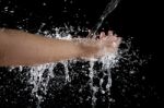 Hand And Pouring Water Splashing On Black Background Stock Photo