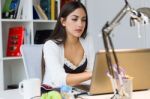 Pretty Young Woman Working With Laptop In Her Office Stock Photo