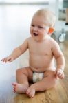 Cute Smiling Baby Sitting At Home Stock Photo