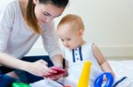 Mother And Baby Girl Using A Smartphone At Home Stock Photo