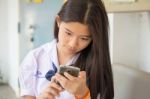 Portrait Of Thai Student Teen Beautiful Girl Using Her Phone And Smile Stock Photo