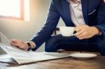 Young Businessman Sitting In A Cafe Drinking Coffee And Reading Stock Photo