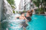 The Kid And Mom Play Together In The Pool Stock Photo