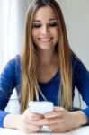 Young Beautiful Woman Using Her Mobile Phone At Home Stock Photo