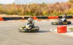 Little Girls Are Driving Go- Kart Car In A Playground Racing Track Stock Photo