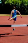 Athlete Jumping Over The Hurdle Stock Photo