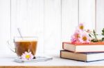 Coffee Cup And Books Or Journal With Flowers Arranged On A Neutral White Painted Desk Stock Photo