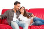 Happy Young Couple Relaxing On Sofa Stock Photo