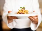 Chef Offering Pasta Salad To You Stock Photo