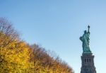 Back View Of The Statue Of Liberty With Autumnal Foliage Stock Photo