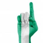 Nigeria Flag On Pointing Up Hand Stock Photo