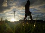 Silhouette  Running On Road At Sunrise Stock Photo