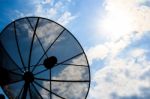 Satellite Dish And Cloudy Sky With Sunbeam Stock Photo