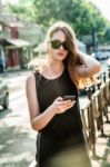 Fashion Woman Walking And Using A Smart Phone Stock Photo