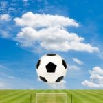 Soccer Ball With Soccer Field Against  Blue Sky Background Stock Photo