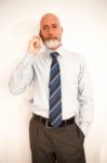 Middle-aged Businessman Listening On Smartphone At Home Stock Photo