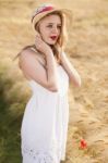 Lonely Beautiful Young Blonde Girl In White Dress With Straw Hat Stock Photo