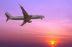 Commercial Airplane Flying At Sunset Stock Photo