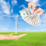 Hand Holding Wind Turbine And Us Dollars Banknote Stock Photo
