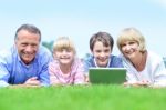 Happy Family Lying On The Grass In Park Stock Photo