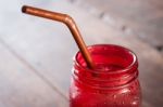 Iced Drink In Red Glass On Wooden Table Stock Photo