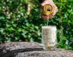 Man Pouring Beer From A Jar Into A Mug Stock Photo