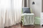 Green Wooden Chair With Grey Pillow And Green Blanket Stock Photo