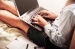 Girl With A Laptop In The Bedroom Stock Photo