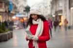 Woman In Red Coat And Wool Cap And Gloves With Smartphone In Han Stock Photo