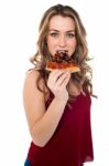 Young Woman Enjoying Yummy Pizza Slice Stock Photo