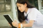 Portrait Of Thai Student Teen Beautiful Girl Using Her Tablet Stock Photo