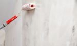 Worker Painting Wall With Glue Roller Closeup Stock Photo