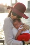 Mom Is Holding Her Baby With The City In The Background Stock Photo