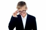 Young Boy Removing Eyeglass Stock Photo