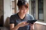 Portrait Of Thai Adult Beautiful Girl Using Her Tablet Stock Photo