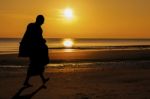 Silhouette Of Monk Walk On The Beach With Beutuful Stock Photo