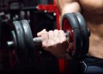 Young Man Doing Heavy Weight Exercise In Gym Stock Photo