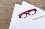 Blank Paper With Pencil And Eye Glasses On Wood Table Stock Photo