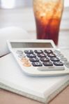 Calculator On Blank Notebook With A Glass Of Cola Stock Photo