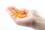 Hand Holding Fish Oil Capsules On White Background Stock Photo