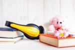 Books Or Journal And Earphone With Flowers Arranged On A Neutral White Painted Desk Stock Photo