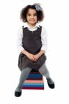 School Girl Sitting On Pile Of Books Stock Photo