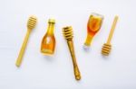 Honey Wooden Dipper And Little Honey Bottle On White Wooden Back Stock Photo