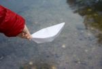 Girl Let A Paper Boat On The River Closeup Stock Photo