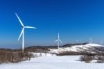 Wind Turbine And Blue Sky In Winter Landscape Stock Photo