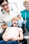 Dentist Operating Teeth  Of Girl Child Stock Photo