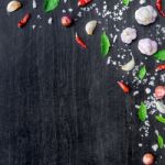 Top View Of Food Ingredients And Condiment On The Table, Ingredients And Seasoning On Dark Wooden Floor Stock Photo