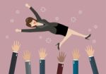 People Throw A Business Woman In The Air Stock Photo