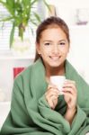 Woman Under Blanket Drinking Tea Stock Photo